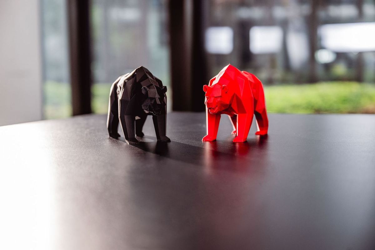 Eine schwarze und eine rote Bären-Figur auf einem Tisch